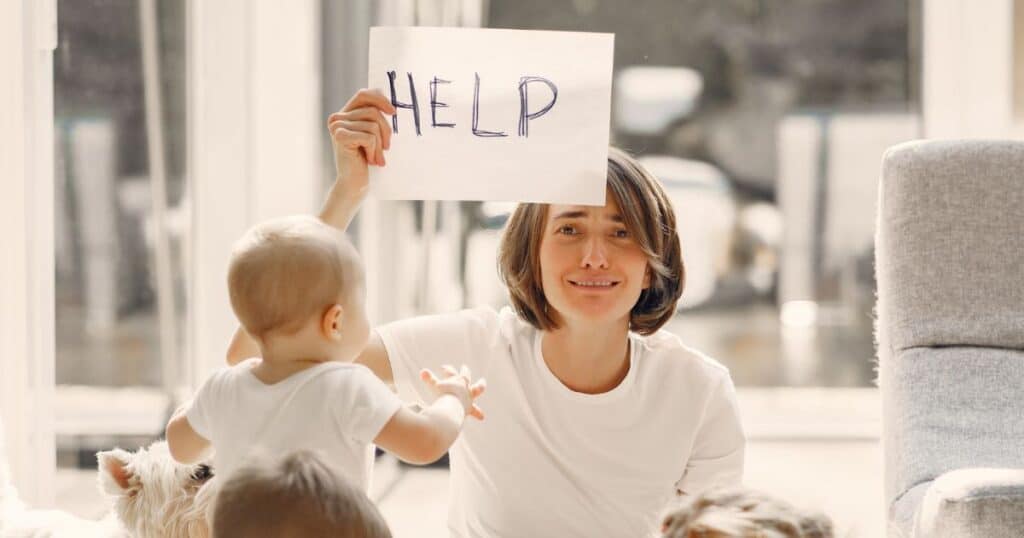 mom holding help a help sign
